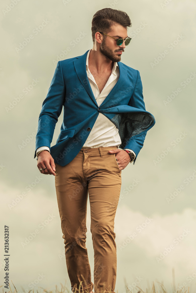relaxed man in blue suit walking on a windy weather relaxed man in blue suit walking on a windy weather
