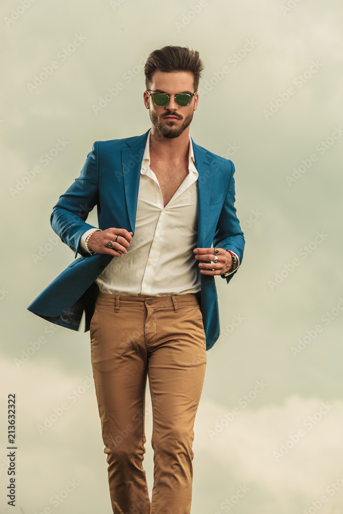 sexy man holding blue suit walking on clouds background sexy man holding blue suit walking on clouds background