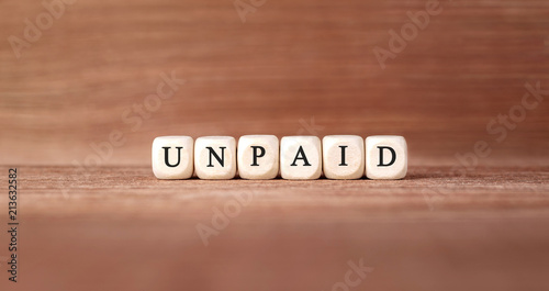 Word UNPAID made with wood building blocks