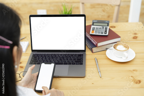 Woman hands using white screen smartphone and laptop mockup for graphic display montage.