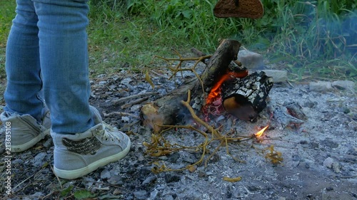 A little girl is preparing bread at the stake. Child near the fire in the campaign photo