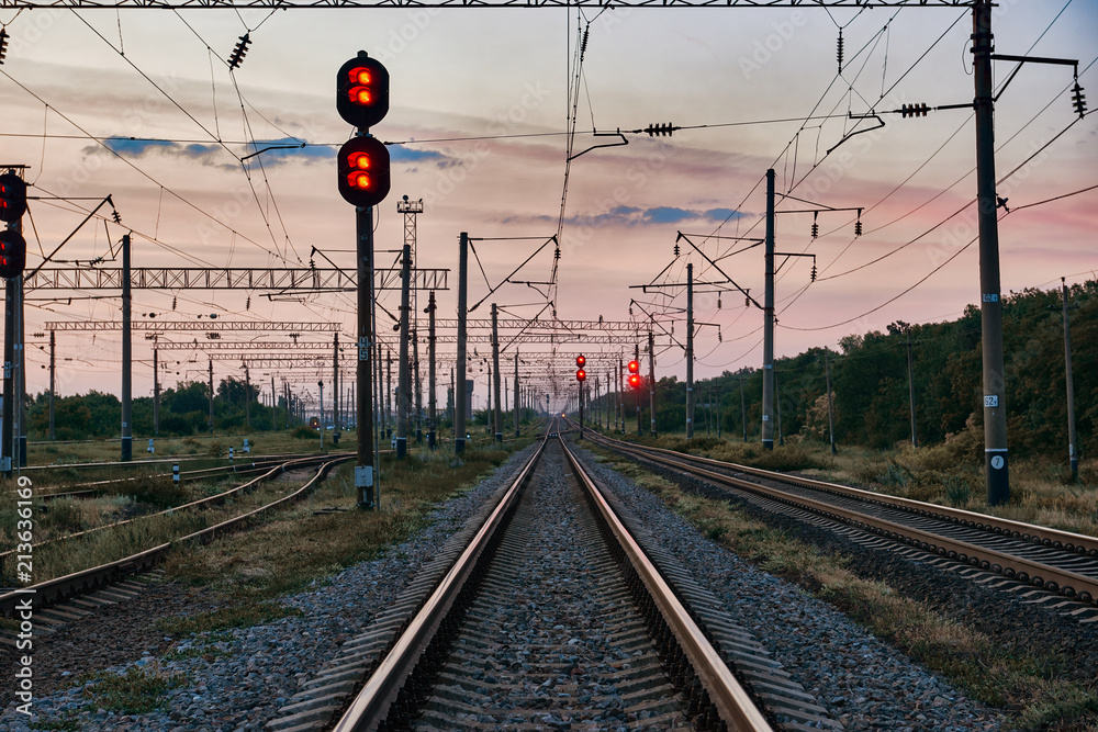 Obraz premium kolejowe światła i infrastruktura podczas pięknego zachodu słońca, kolorowe niebo, transport i koncepcja przemysłowa
