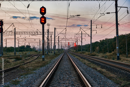 railroad traffic lights and infrastructure during beautiful sunset, colorful sky, transportation and industrial concept