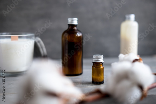 Spa cosmetics in brown glass bottles on gray concrete table. Copy space. Beauty blogger, salon therapy, minimalism concept