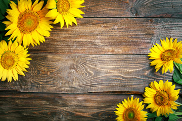 Beautiful sunflowers on a wooden table. View from above. Background with copy space.