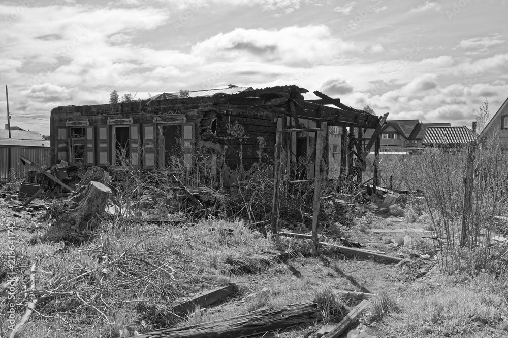 Old burnt house against cloudy sky as black and white image. Komsomolsk-on-Amure, Russia