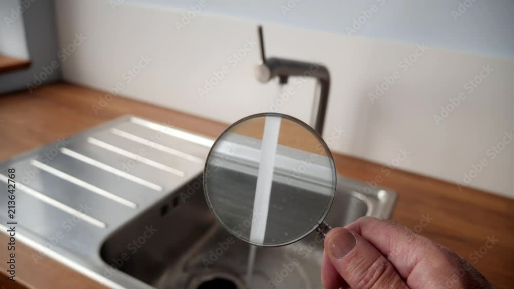 Tap water under a magnifying glass.

A stream of tap water being looked at using a magnifying glass.