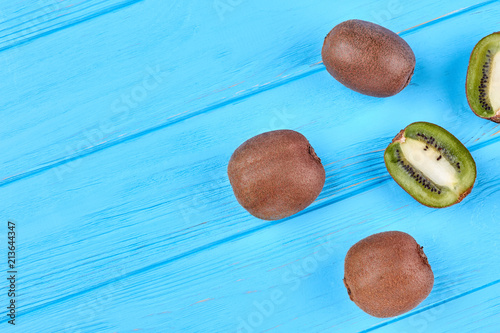 Ripe kiwi fruits and copy space. Juicy kiwi fruits on blue wooden background with text space. Halthy eating concept. photo