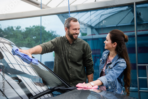 boyfriend and girlfriend cleaning car with rags at car wash © LIGHTFIELD STUDIOS