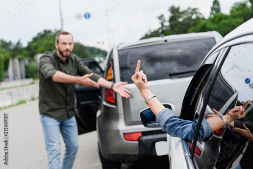 cropped image of driver showing middle finger to man on road © LIGHTFIELD STUDIOS