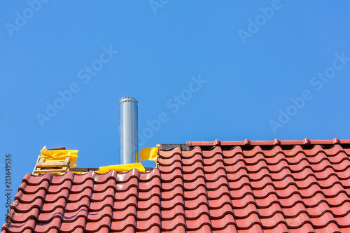 New roof with roof tiles and chimney pipe