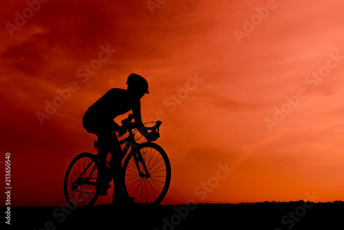 Silhouette of the cyclist riding a road bike at sunset.Mountain bicycle and man.Life style outdoor