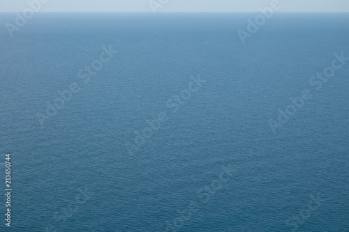 Uninterrupted panoramic sea view with blue calm surface and thin horizon line above. Copy space for your text or advertising content on peaceful limitless ocean. Summer, vacation and resort concept