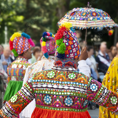 Several dancers dancing and wearing the traditional folk costume from India