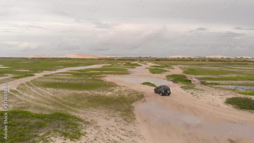 cars driving on sandy road near the beach in Jericoacoara, Brazil cars driving on sandy road near the beach in Jericoacoara, Brazil