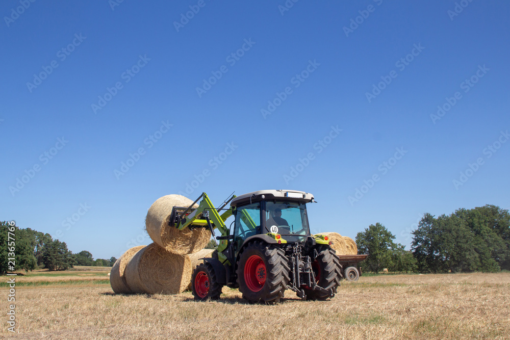 Obraz premium traktor lädt heuballen
