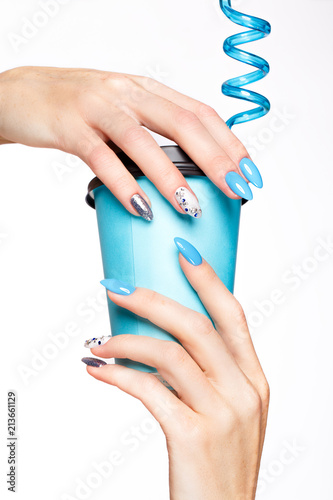 Beautiful summer blue manicure with crystals on female hand. Close-up. Picture taken in the studio