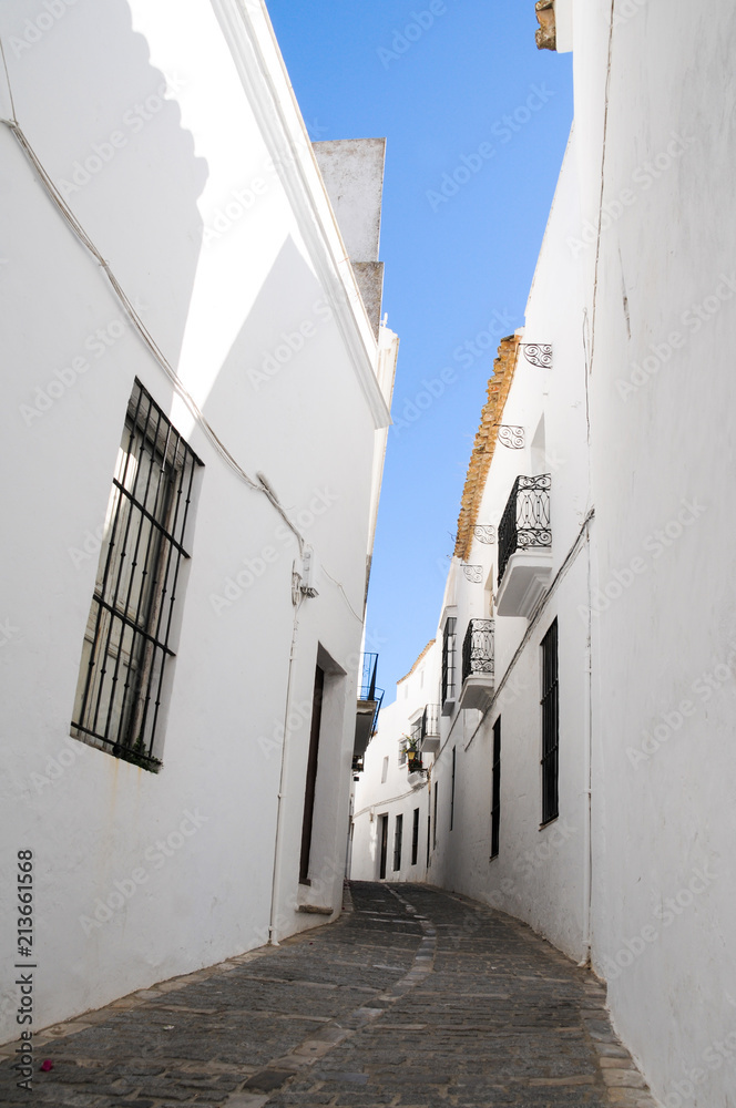 Empty street going up hill through white houses in Vejer, Andalusia. Tourist attraction, summer vacation, guided tour, travel destination concepts