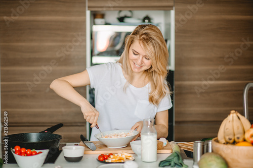 close up portrait of joyful woman with a plte of salad at home. bake cake. cook cake. dough for baking. photo