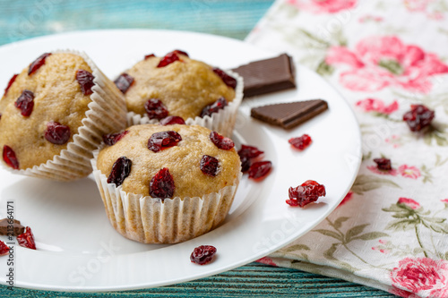 Homemade cupcakes with cherries are located on a light background. A few cupcakes are located on a white plate