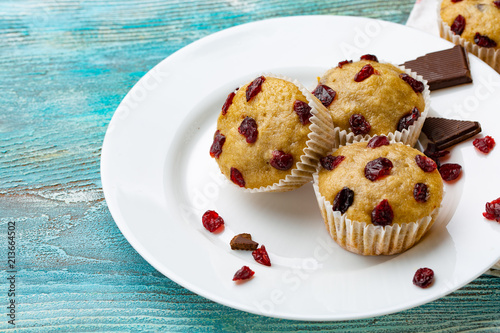 Homemade cupcakes with cherries are located on a light background. A few cupcakes are located on a white plate