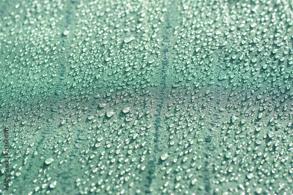 Obraz premium Rain drops on a turquoise textile surface