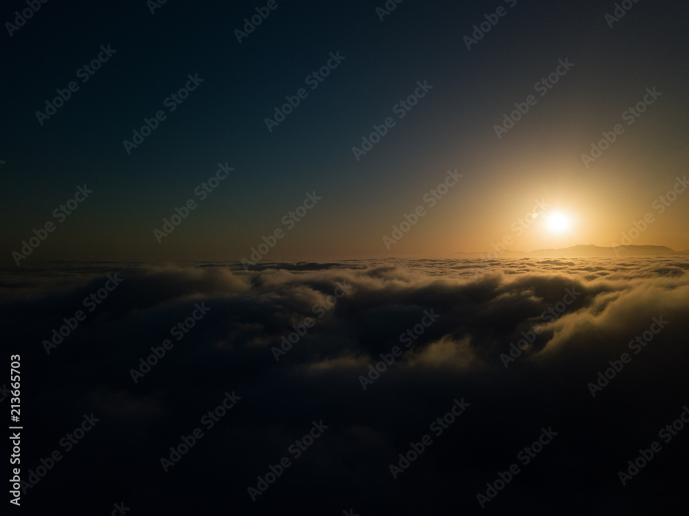 Sunrise in a distance, mountains, clouds, and sun Sunrise in a distance, mountains, clouds, and sun