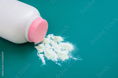 Baby talcum powder container on green background with copy space photo
