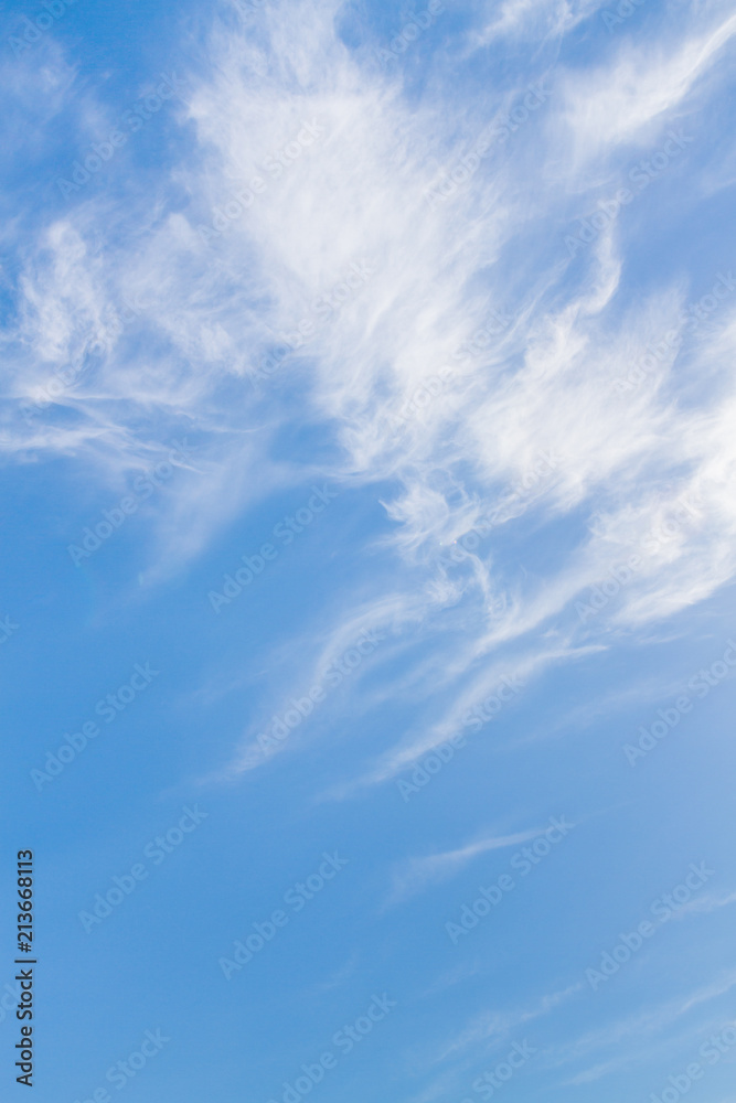 White feathery clouds on the blue sky in summer