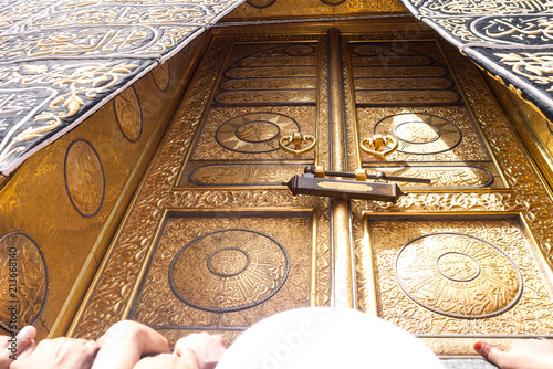 MECCA, SAUDI ARABIA - MAY 01 2018: The golden doors of the Holy Kaaba closeup, covered with Kiswah. Massive lock on the doors. Entrance to the Kaaba in Masjid al Haram photo