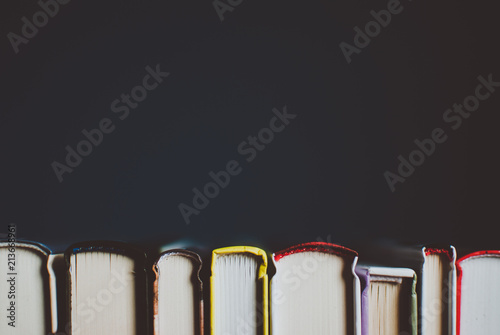 Open new colorful books standing on the wooden table. Closeup of pages. Abstract concept of knowledge, education, learning, and literature. photo