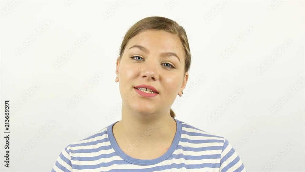 Happy young woman welcomes and smiles. Online video chat on a gray background Happy young woman welcomes and smiles. Online video chat on a gray background