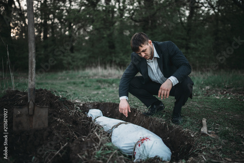 Obraz na płótnie Maniac against grave, serial murderer concept