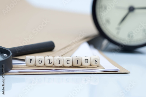 The concept of policies. Words use blocks of wood on files and documents. Selective Focus.