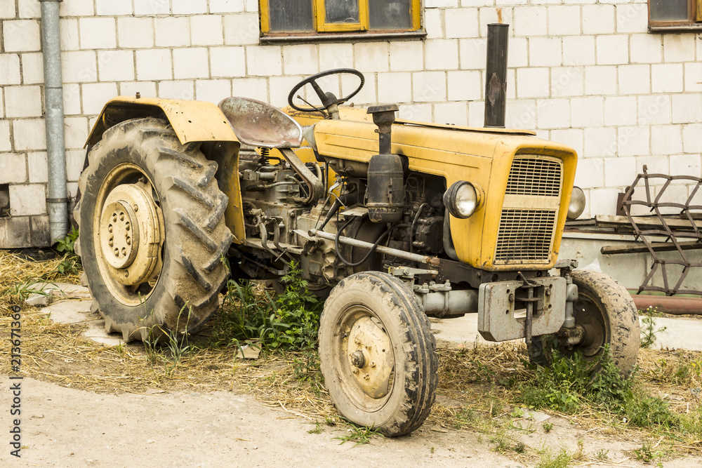 An old tractor produced in the 70s of the 20th century. General view of the agricultural machine. The necessary equipment for a dairy farm. An old tractor produced in the 70s of the 20th century. General view of the agricultural machine. The necessary equipment for a dairy farm.