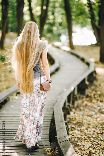 beautiful young girl with long hair in a dress on the street