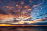 Dramatic sunrise clouds. Very structured and colorful sky. Blue, orange, pink, yellow. Sun rising on horizon about sea. Adventure, clean, sail, free, quiet, relax, holiday.