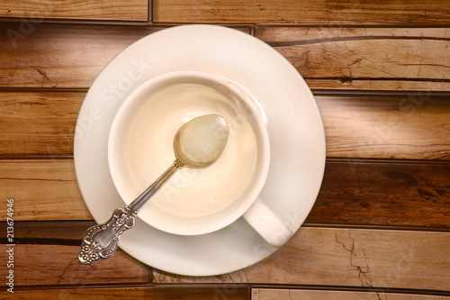 white cup on a saucer on a wooden background