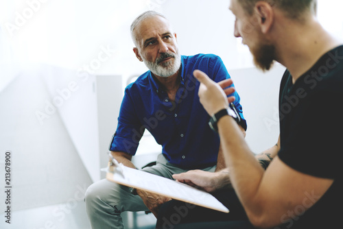 Professional journalists discussing new assignment from the publisher to cover all the points of the upcoming international summit. CEO and manager talking on a new company sales report in the office.