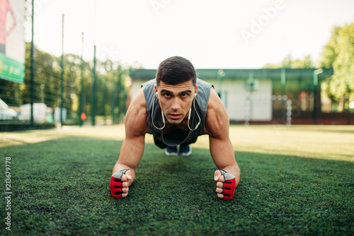 Man doing push-up exercise on a grass outdoor © Nomad_Soul