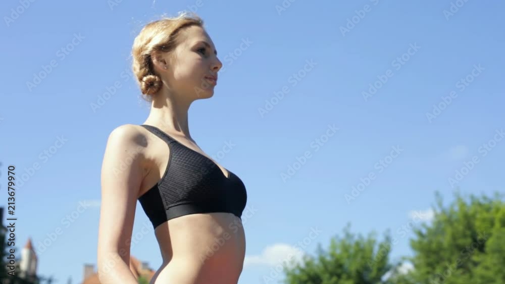 Yoga woman standing, holding yoga mat. Steadycam shot. Yoga woman standing, holding yoga mat. Steadycam shot.