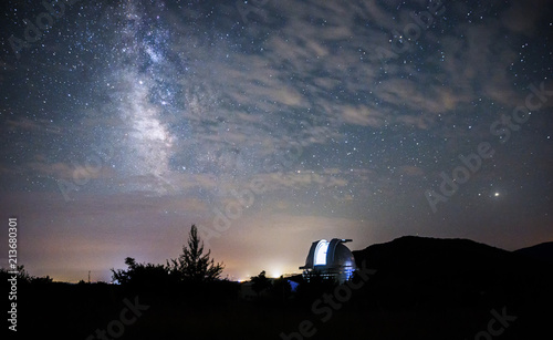 Open dome of a big telescope in an observatory in the background of the starry sky photo