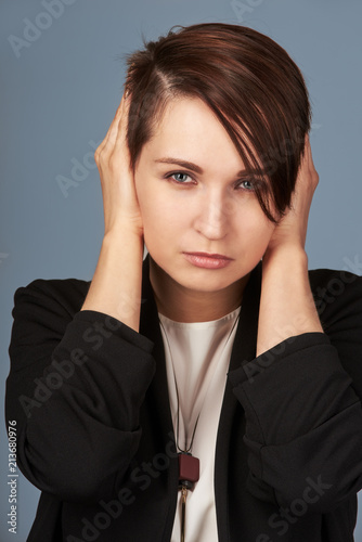 Sad tired young woman closing her ears with hands