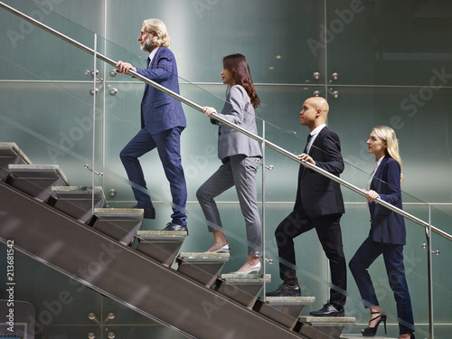 multinational and multiethnic corporate business people walking up stairs in a line