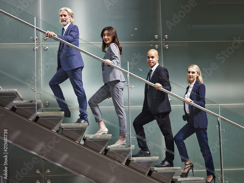 multinational and multiethnic corporate business people lined up on stairs of modern office building