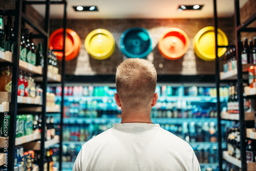 Male customer choosing drinks in supermarket Male customer choosing drinks in supermarket