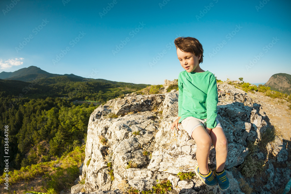 A boy on top of a mountain.