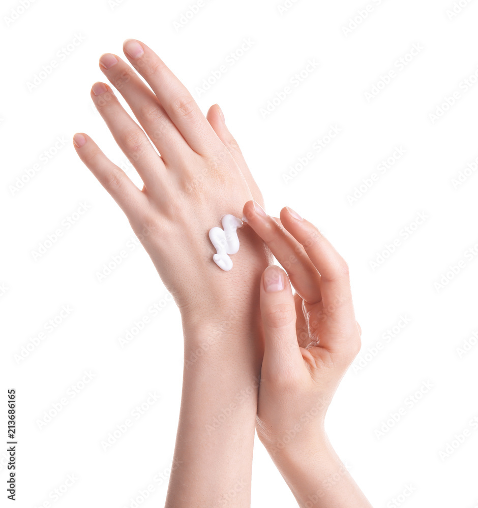 Young woman applying hand cream against on white background Young woman applying hand cream against on white background