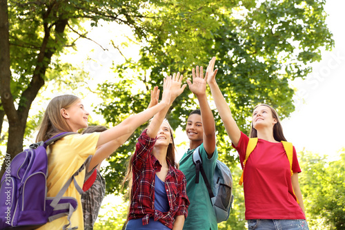 Group of children putting hands together outdoors. Summer camp