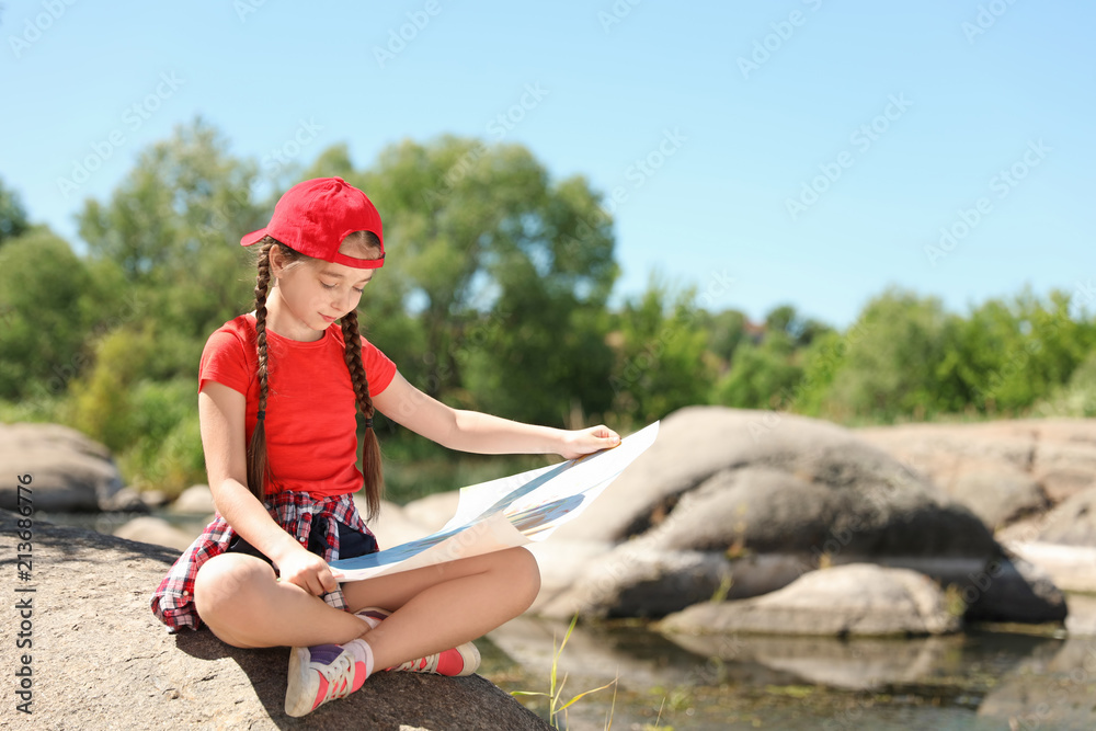 Little girl with map outdoors. Summer camp
